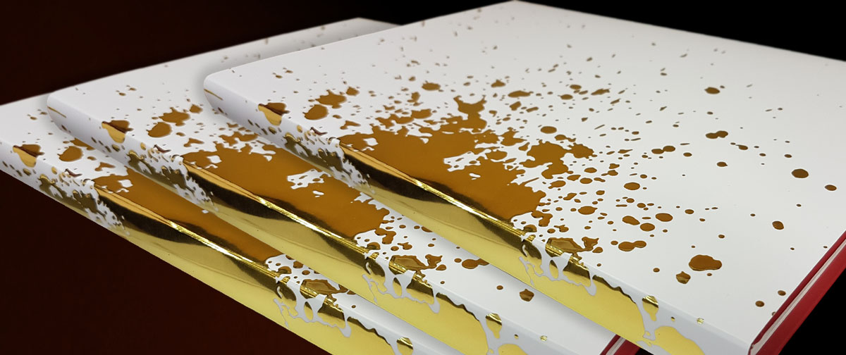 Un diseño realizado con stamping oro para la sobrecubierta de un libro - simula ser una mancha de oro esparcida sobre una superficie blanca - Truyol Digital