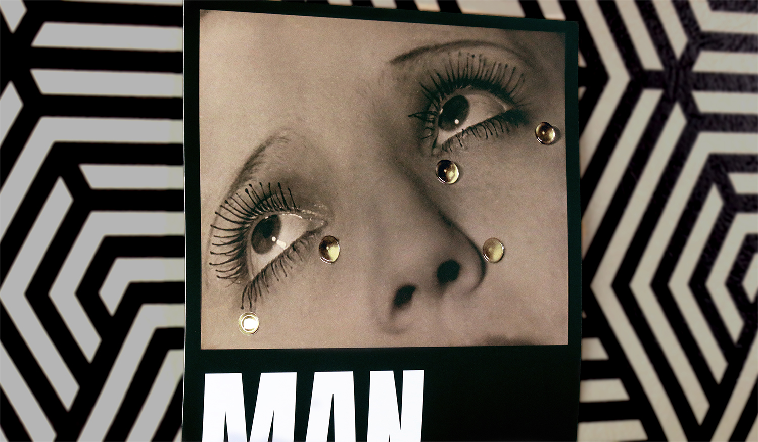 La mítica imagen 'Les Larmes' de Man Ray revive con un impactante realce gracias al acabado cristal. Las lágrimas, impresas con volumen y brillo, contrastan con la textura mate del fondo, aportando un efecto tridimensional que llama la atención incluso a distancia.