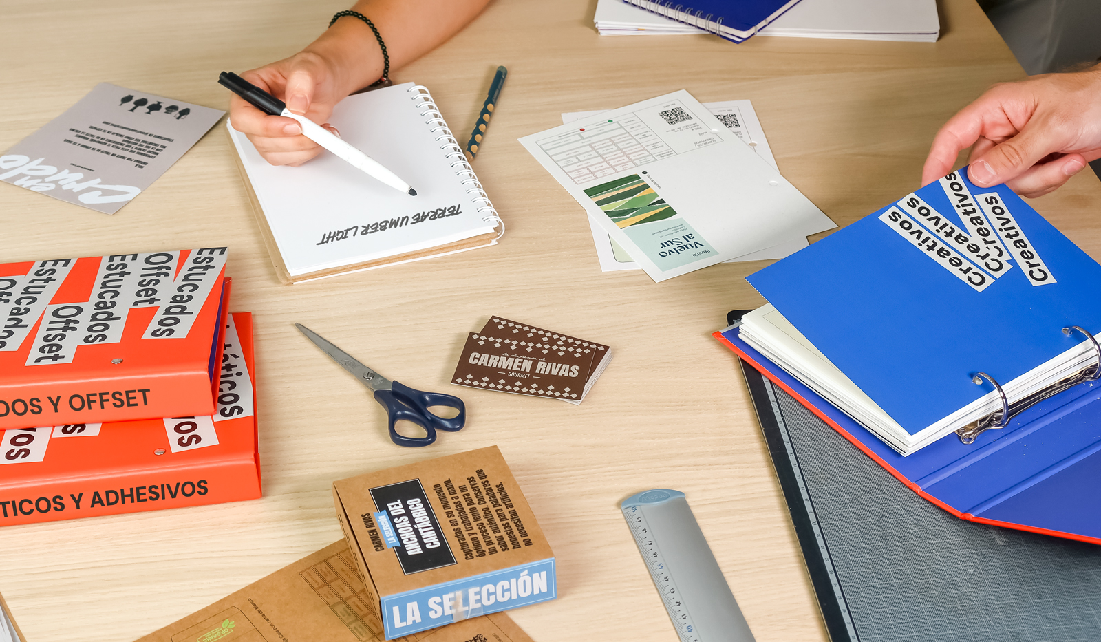 Mesa de trabajo para elegir entre los tipos de papel para imprimir con catálogos de Truyol